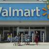 People wearing protective masks walk from a Walmart store on May 18, 2021 in Hallandale Beach, Florida.