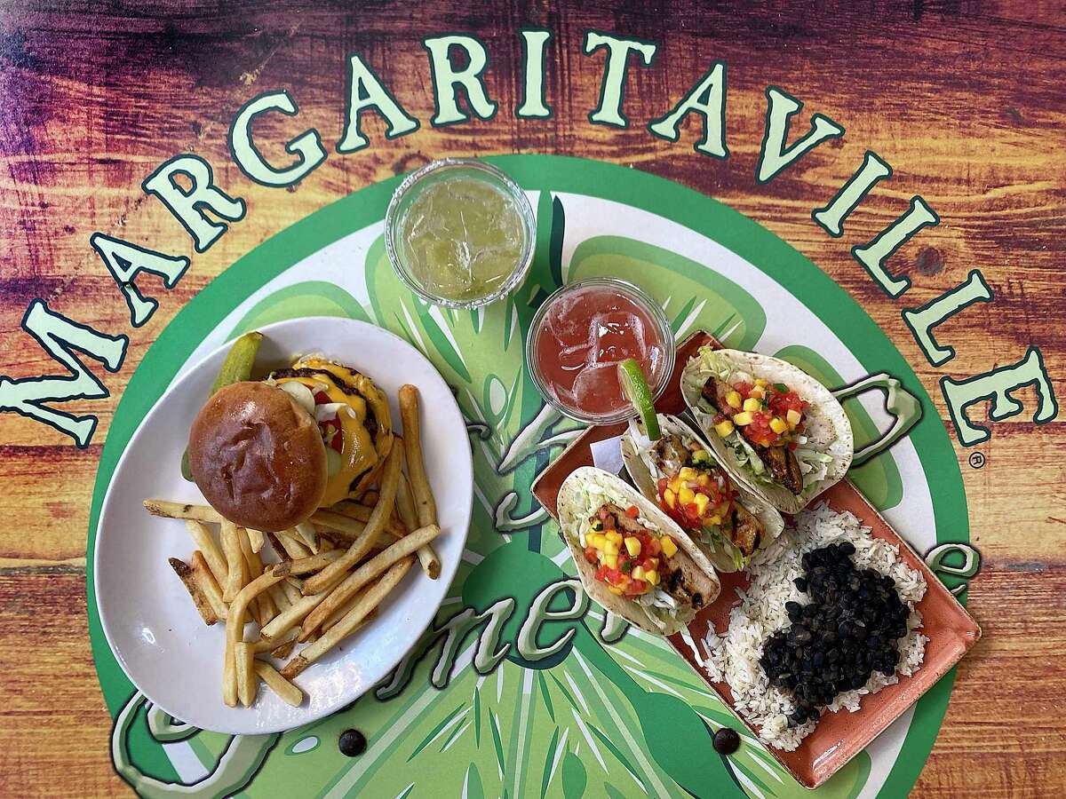 Margaritaville capitalizes on the image of singer Jimmy Buffett with his Double Cheeseburger in Paradise, left, the Perfect Margarita, a watermelon margarita and grilled fish tacos on the River Walk.