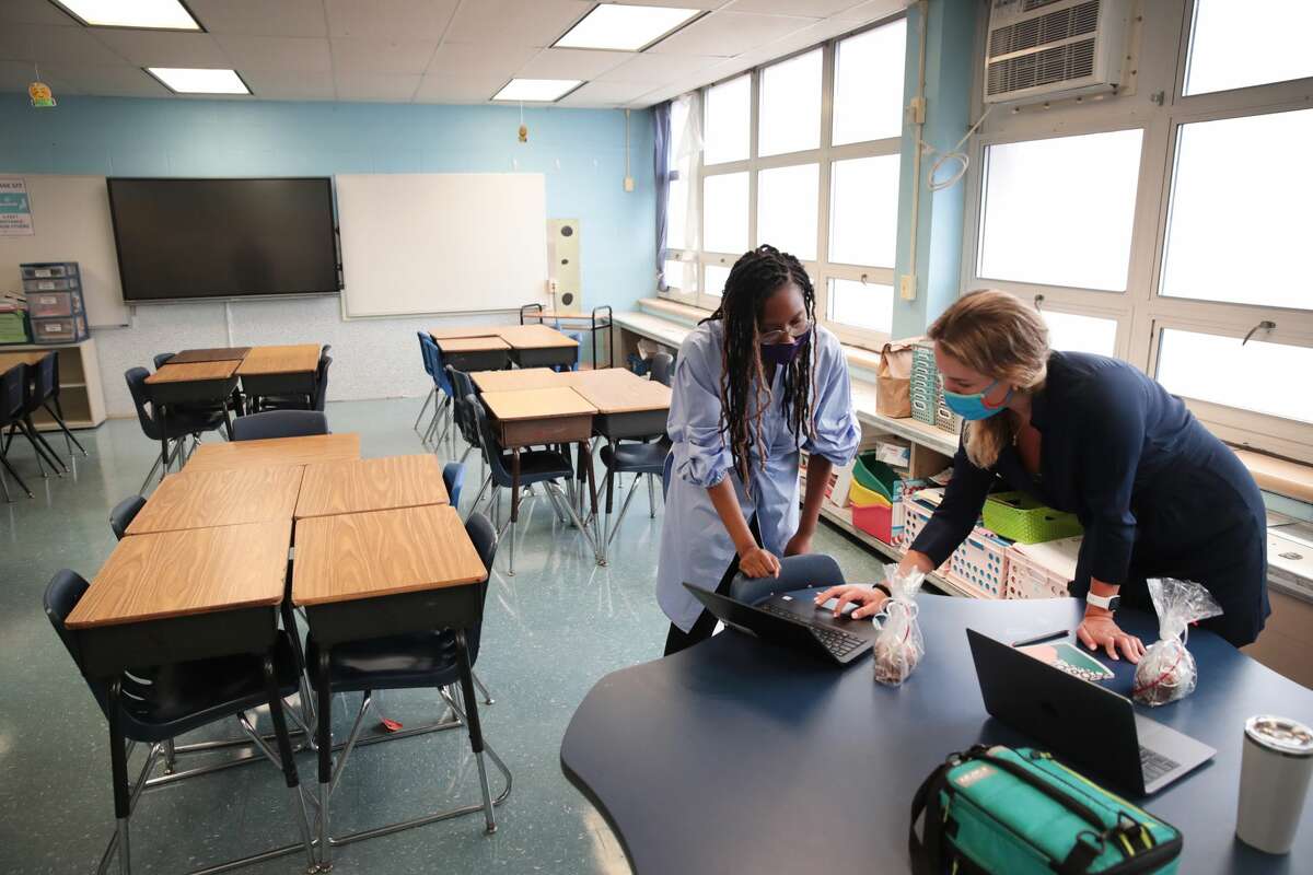 Jasmine Gilliam (L) and Lucy Baldwin, teachers at King Elementary School, prepare to teach their students remotely in empty classrooms during the first day of classes on September 08, 2020 in Chicago, Illinois. (Photo by Scott Olson/Getty Images)