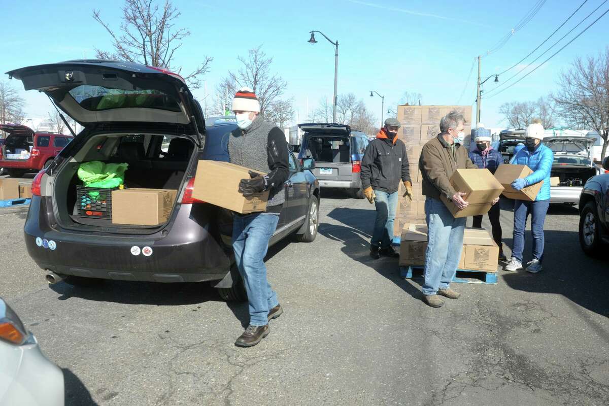 Volunteers load food into waiting vehicles during the weekly CT Food Bank/Foodshare food donation at Calf Pasture Beach, in Norwalk, Conn. Feb. 17, 2021.