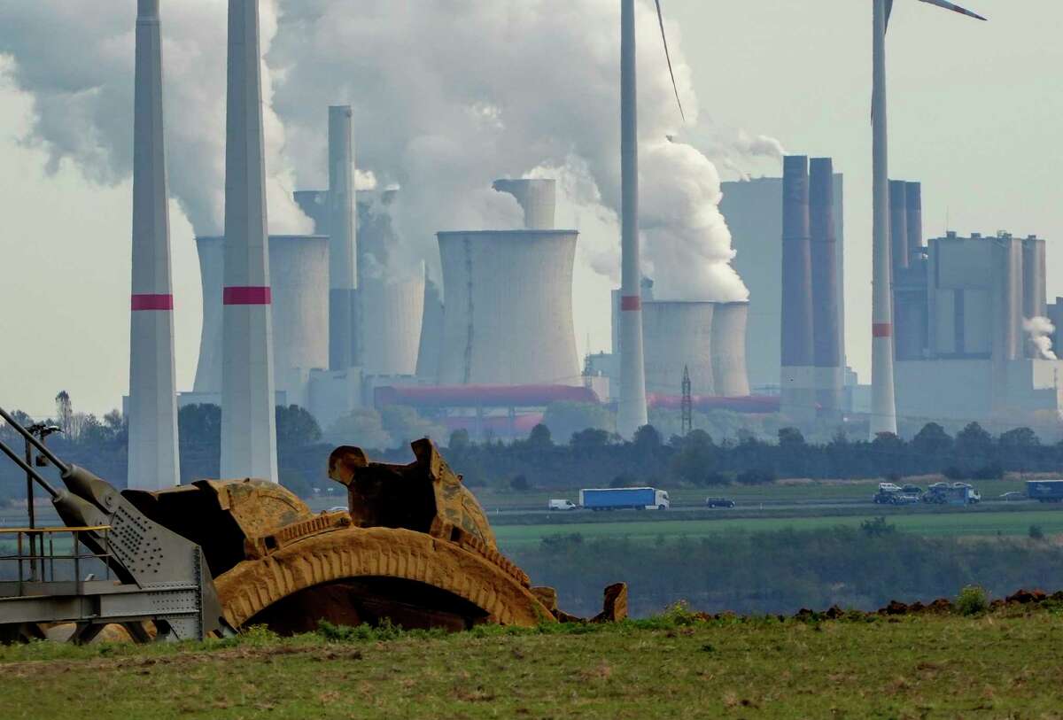 Steam comes out of the chimneys of the coal-fired power station Neurath near the Garzweiler open-cast coal mine in Luetzerath, Germany, Monday, Oct.25, 2021. The climate change conference COP26 will start next Sunday in Glasgow, Scotland.