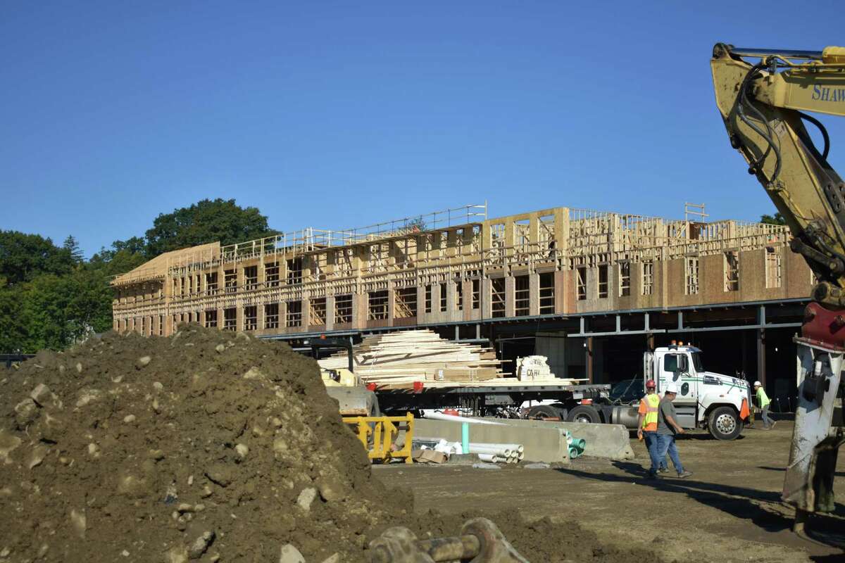 Construction proceeds in September 2021 on a new apartment building across from a Darien, Conn. stop of Metro-North. Connecticut is counting on a continued influx of young professional from New York City to reinvigorate its economy during an extended period of remote working.