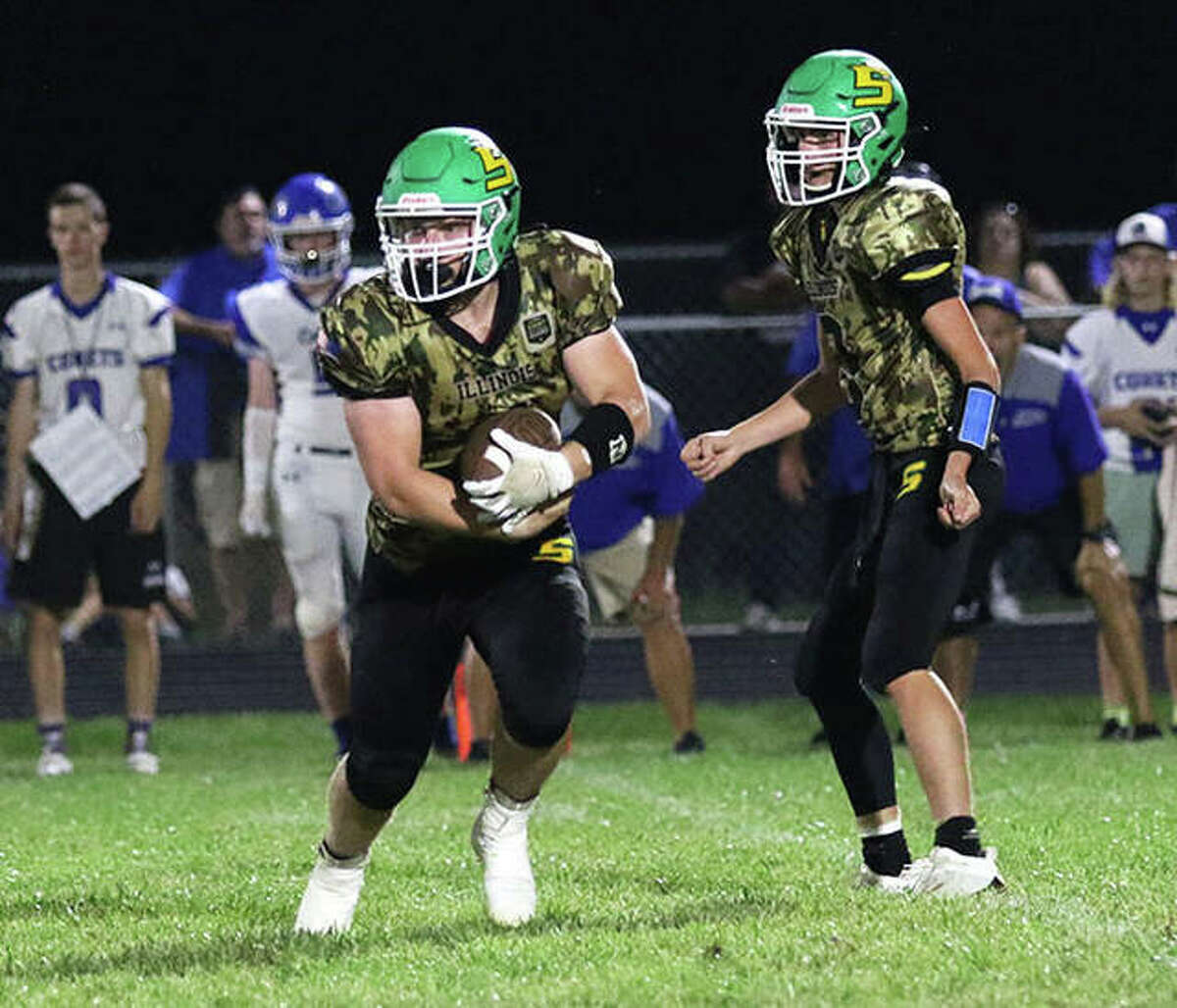 Southwestern’s Blake Funk (left) looks for running room after taking a handoff from QB Quinten Strohbeck during a Sept. 17 game against Greenville in Piasa. The 5-4 Piasa Birds, in the playoffs for the first time since 2009, play Saturday at 9-0 Benton.