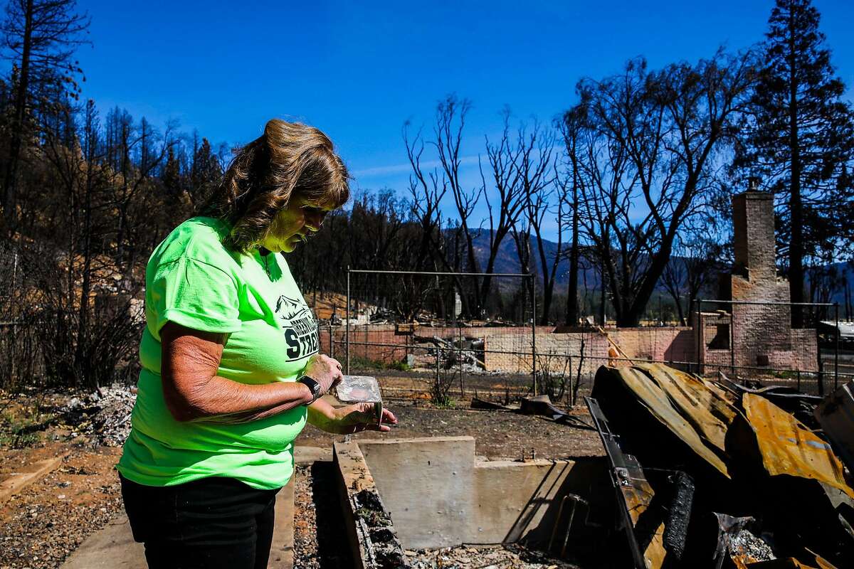 Karen Morcomb, 62, inspects an item her sister-in-law Yolanda Danner, 59, (not pictured) found on her property on Wednesday, September 29, 2021, in Greenville, Calif. Morcomb's home, which had been in her family since 1912, was destroyed during the Dixie Fire in August. "But that whole mountain right there, I can show you a picture, what happened was we were out for two weeks and then they said we could come back home. So we came back home and I just felt really funny about it. So like five o'clock in the morning, I came out here and I took a picture of it. That whole thing was glowing, glowing behind there. But yeah, that whole mountain is what took it out. But they didn't even try. I mean, there's no hose laid. There's no nothing," Morcomb said. "And they couldn't even save one house in this town? And the thing was it had been burning for days. Why they just let it get so out of control and not save Greenville. And if you go like (to) Taylorsville and all around, you'll see hose lays, you see those buckets of water. You will not find one in this town. I don't know why they did what they did. And then I don't know why the governor came and said that, you know, was wiped off the map. We're not wiped out. I mean, that was just rude, in my opinion. And that's kind of why I'm so upset about it, is my family was here for all this time. We paid taxes for over 100 years. We should have been helped."