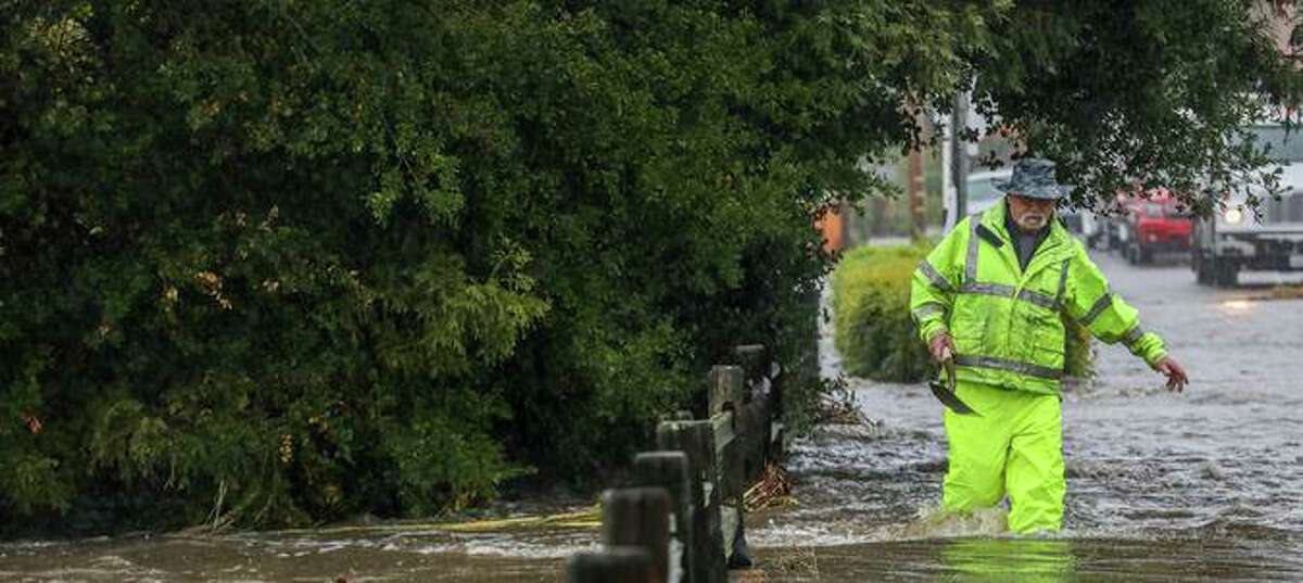 A man walks through floodwaters on Tachevah Drive in Santa Rosa last Sunday.