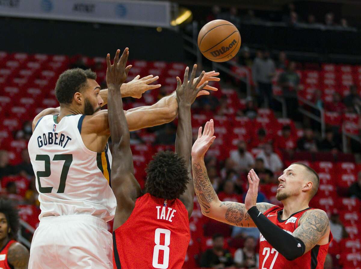 Utah Jazz center Rudy Gobert (27) passes over Houston Rockets forward Jae'Sean Tate (8) during the first half of an NBA game between the Houston Rockets and Utah Jazz on Thursday, Oct. 28, 2021, at Toyota Center in Houston.