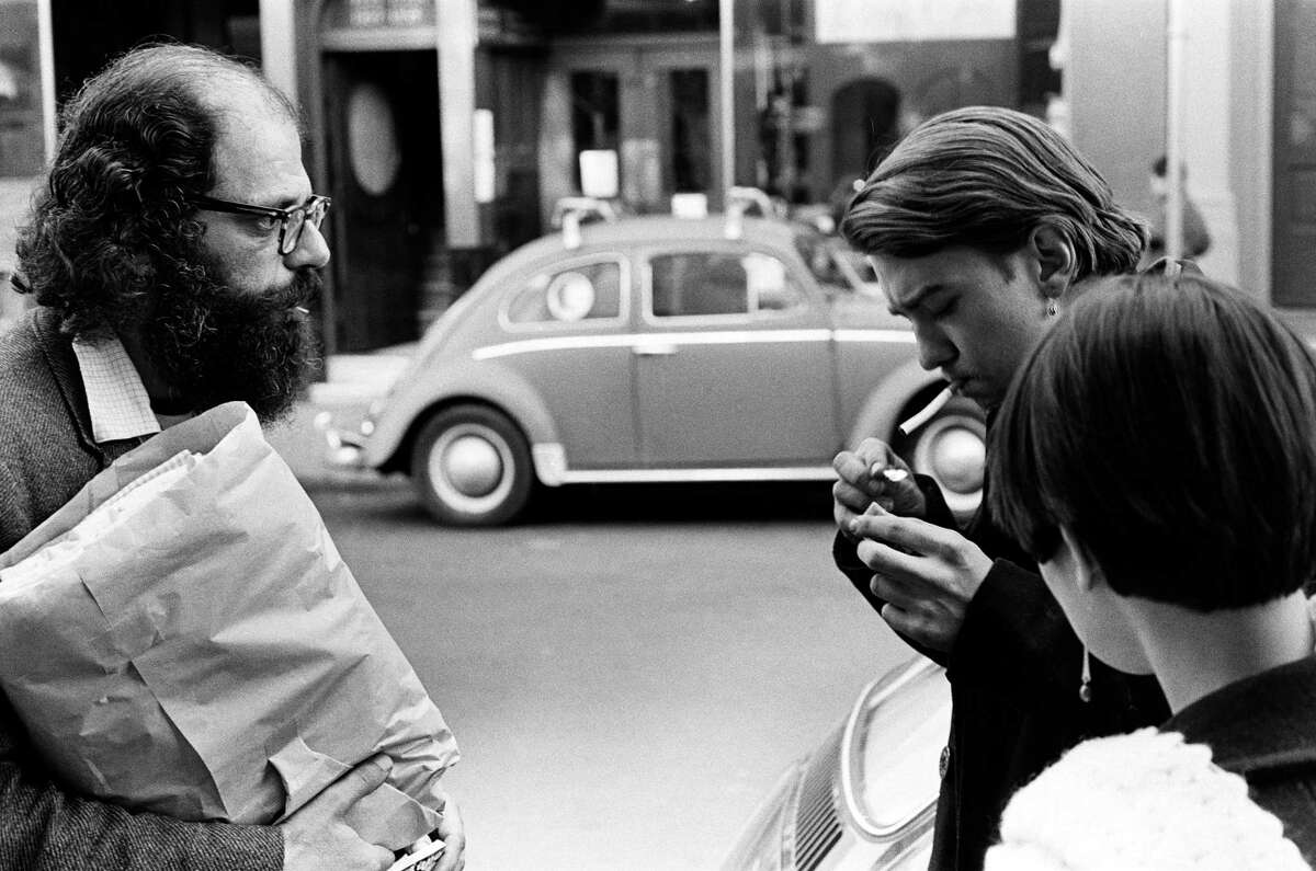 Beat poet Allen Ginsberg chats with hippies on a street corner in San Francisco in early summer 1967.