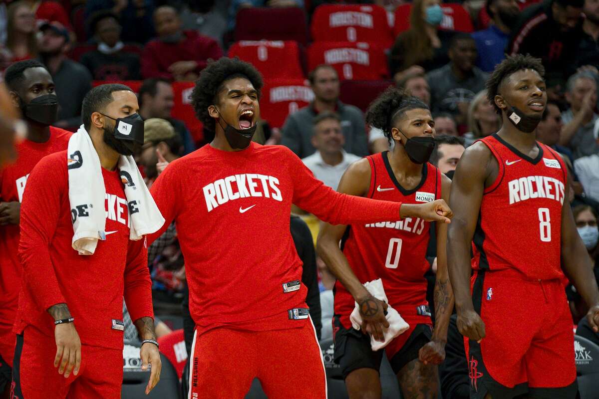 Houston Rockets guard Josh Christopher (9) reacts from the bench as Houston Rockets center Alperen Sengun (28) puts in a put-back slam during the second half of an NBA game between the Houston Rockets and Utah Jazz on Thursday, Oct. 28, 2021, at Toyota Center in Houston.