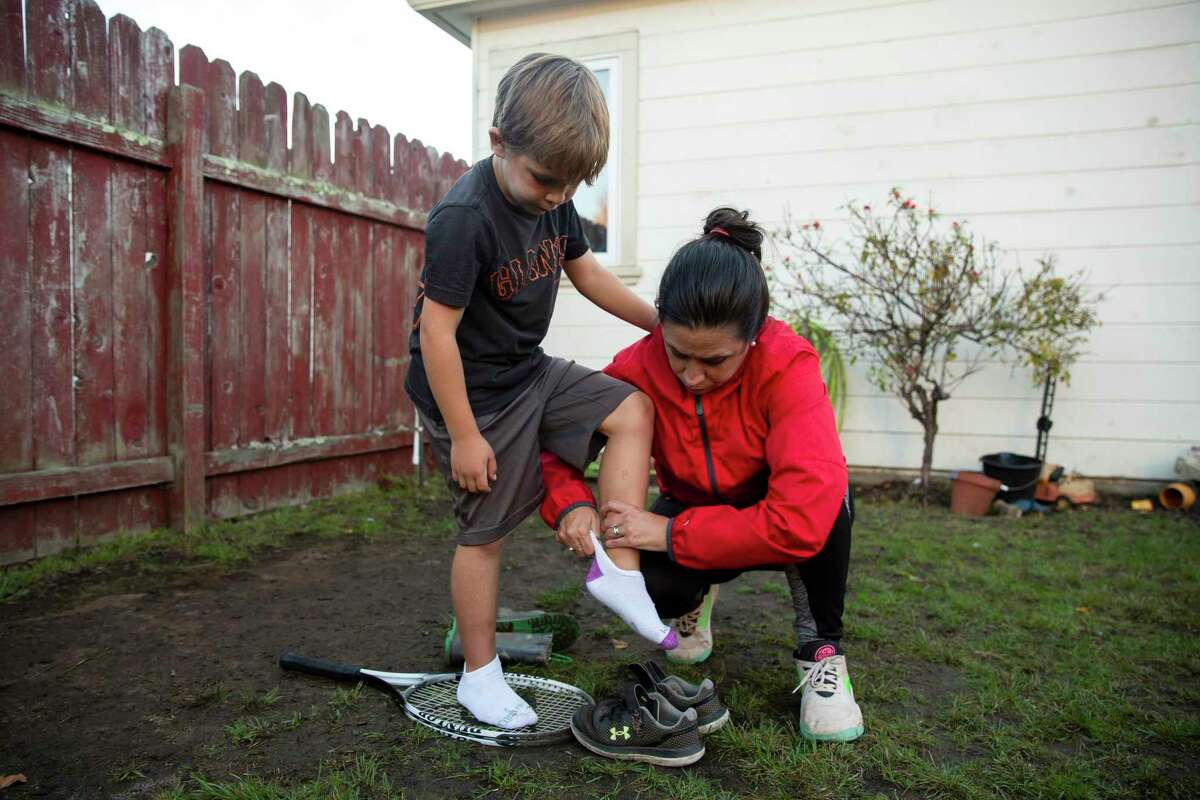 Michelle Aslestine helps her son Cole, 6, put on a pair of shoes in the backyard of their El Cerrito home. Five- to 11-year-olds could start getting vaccinated as soon as Nov. 4.