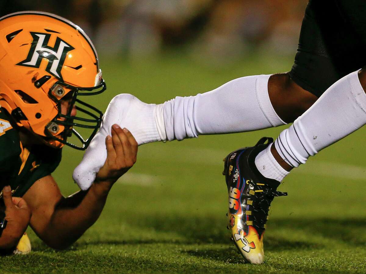 Brennan’s Jason Love (4) loses his shoe as Holmes’ Jozsef Leos (34) stops him from advancing the ball for a first down during the first quarter at Gustafson Stadium in San Antonio, Texas, Thursday, Oct. 28, 2021.