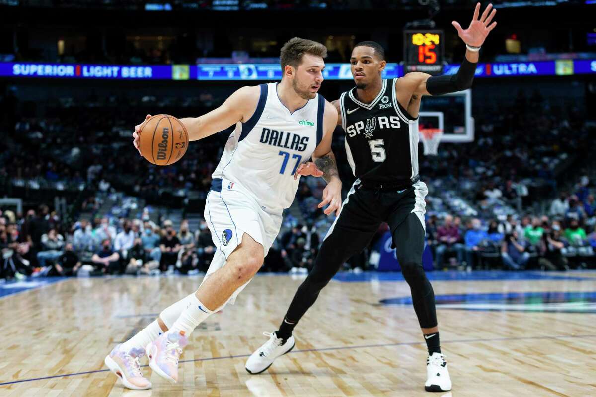 Dallas Mavericks guard Luka Doncic (77) is defended by San Antonio Spurs guard Dejounte Murray (5) during the first half of an NBA basketball game Thursday, Oct. 28, 2021, in Dallas. (AP Photo/Sam Hodde)