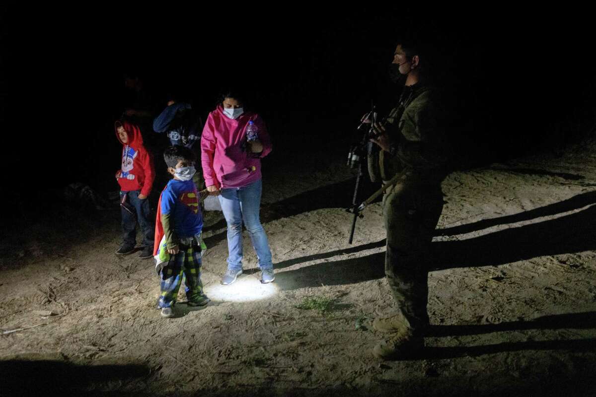 ROMA, TEXAS - APRIL 30 - A Honduran boy, 5, peers at a U.S. National Guard soldier after he crossed the Rio Grande with his mother on April 30, 2021 in Roma, Texas. A surge of mostly Central American immigrants crossing into the United States, including record numbers of children, has challenged U.S. immigration agencies along the U.S. southern border. (Photo by John Moore/Getty Images)