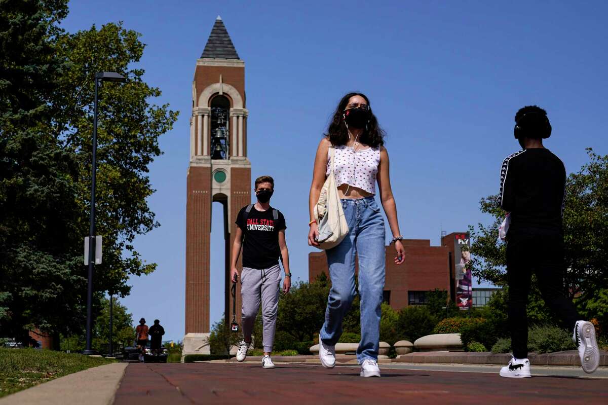 Masked students walk through the campus of a university earlier this year.