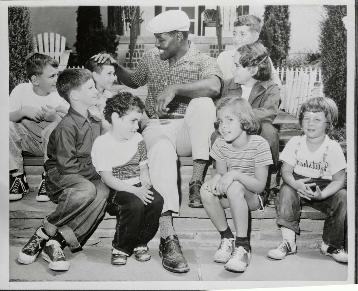 Ezzard Charles takes a time out from training for his forthcoming heavyweight bout with champion Rocky Marciano to play with his small fans at Kutsher's Hotel and Country Club in Thompson on May 20, 1954.