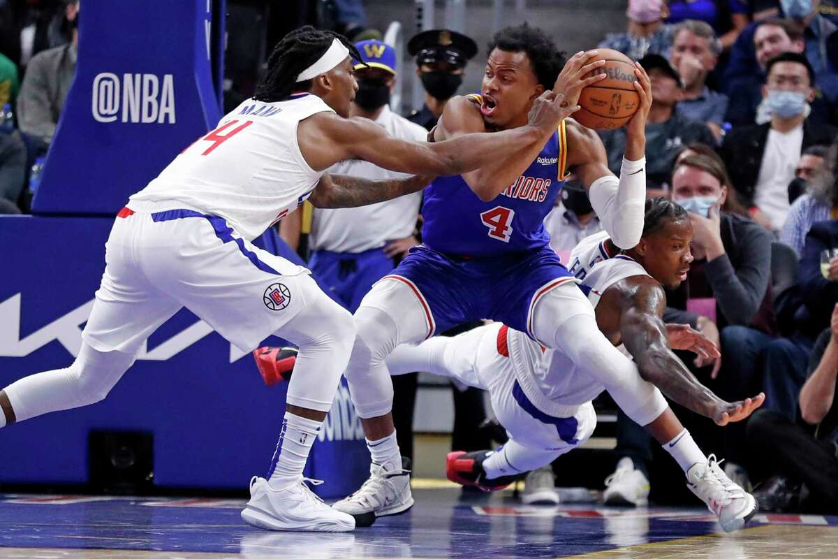 Golden State Warriors' Moses Moody secures the ball against Los Angeles Clippers' Terance Mann and Eric Bledsoe in 2nd quarter during NBA game at Chase Center in San Francisco, Calif., on Thursday, October 21, 2021.