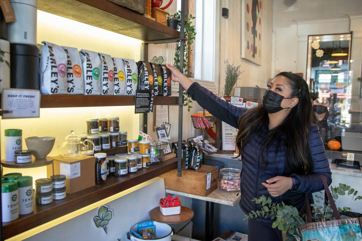 Dr. Jennifer Labit reaches for a bag of coffee beans brewed at Farley's in San Francisco on Oct. 28, 2021. Farley's has been a neighborhood institution since it opened in 1989.