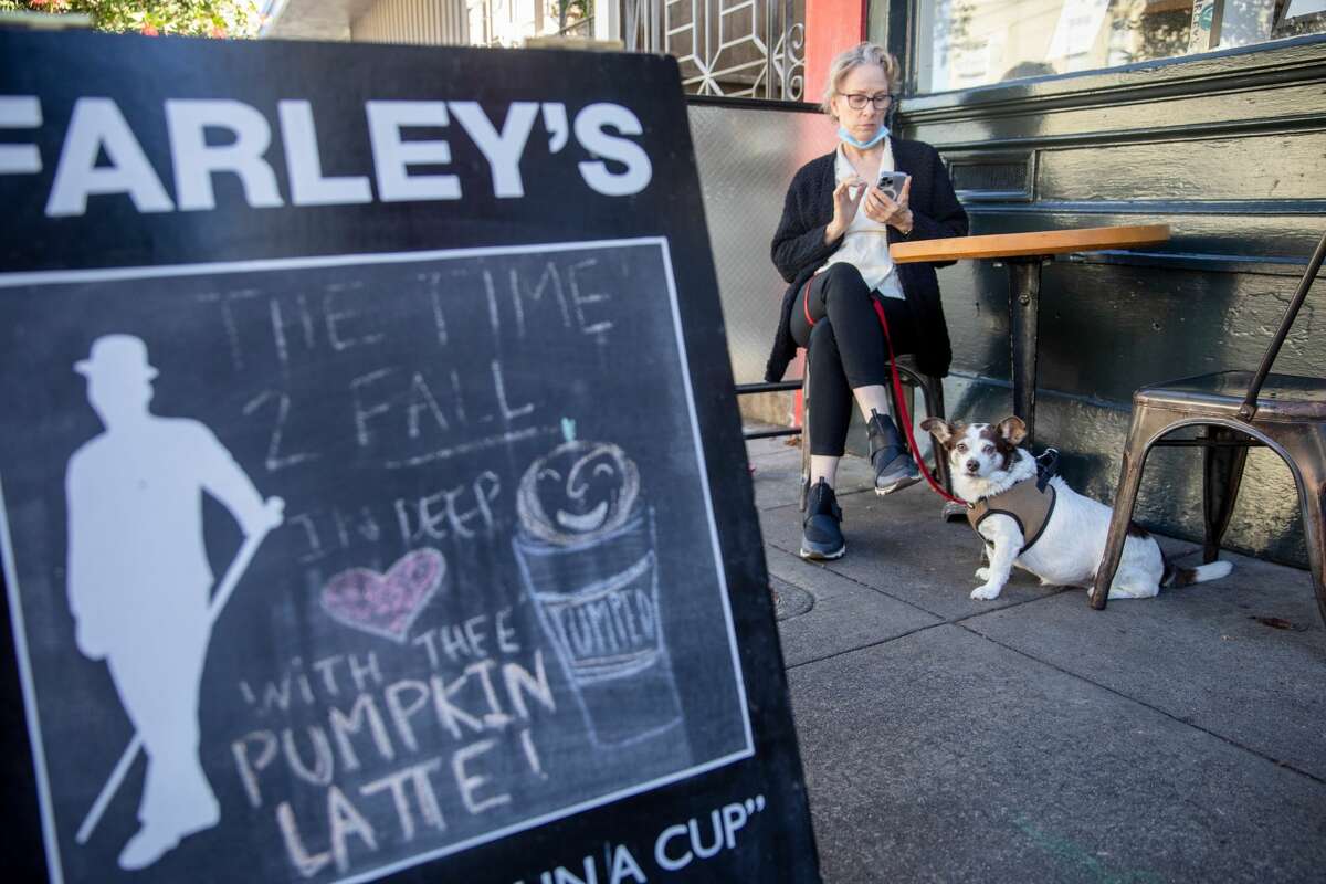 Customer Robin Evans hangs out with her dog Emily at Farley's in San Francisco on Oct. 28, 2021. Farley's has been a neighborhood institution since it opened in 1989.
