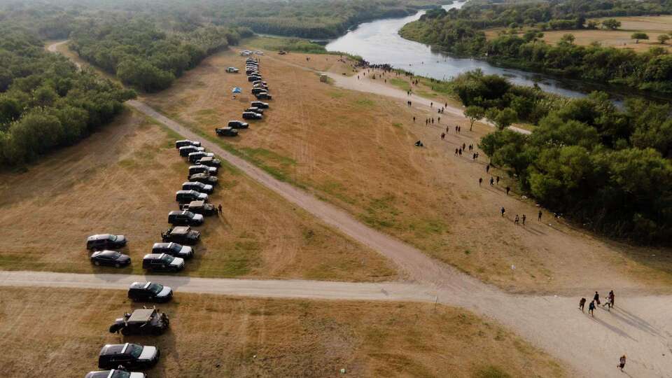 Official vehicles line up along the bank of the Rio Grande near an encampment of migrants, many from Haiti, near the Del Rio International Bridge, Tuesday, Sept. 21, 2021, in Del Rio, Texas. The U.S. is flying Haitians camped in a Texas border town back to their homeland and blocking others from crossing the border from Mexico. (AP Photo/Julio Cortez)