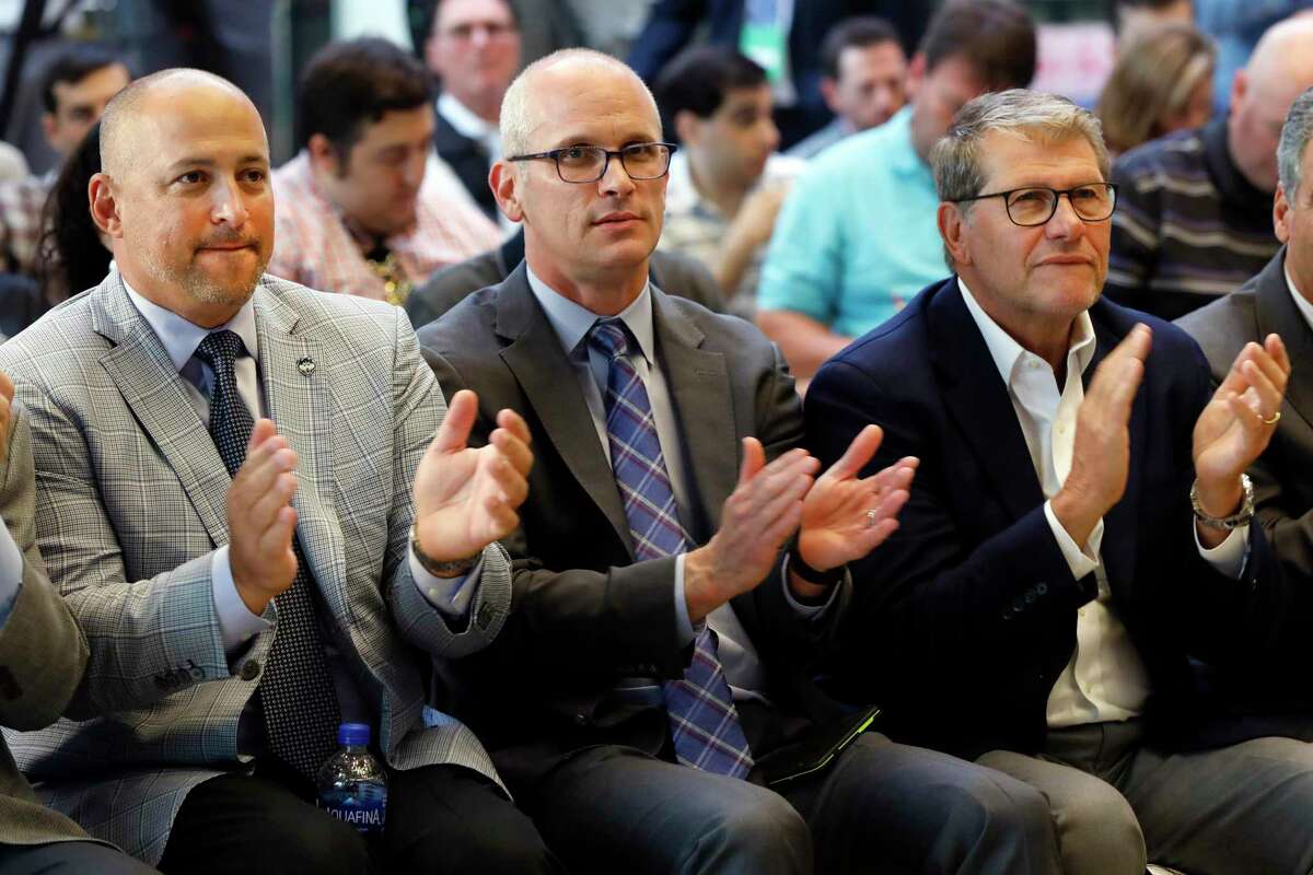 UConn Director of Athletics David Benedict, left, men's basketball coach Dan Hurley, center, and women's basketball coach Geno Auriemma applaud during the announcement that the University of Connecticut is re-joining the Big East Conference, at New York's Madison Square Garden, Thursday, June 27, 2019. (AP Photo/Richard Drew)