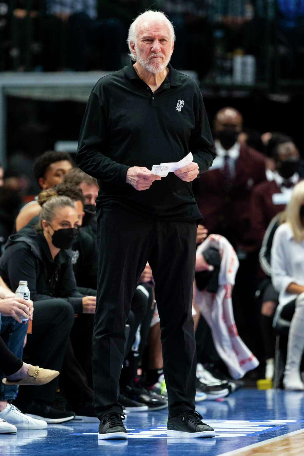 San Antonio Spurs coach Gregg Popovich watches play during the second half of the team's NBA basketball game against the Dallas Mavericks, Thursday, Oct. 28, 2021, in Dallas. (AP Photo/Sam Hodde)