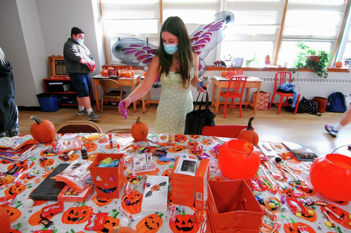 Coco Calvanese, a member of Greenwich High School's Students Give Back club, puts candy out for children at Community Centers Inc. in Greenwich, Conn., on Thursday October 28, 2021. Several students from GHS's CCI Club and Students Give Back Club helped the kids decorate pumpkins, hid candy around the rooms for them, played games, did facepainting and other fun Halloween activities.