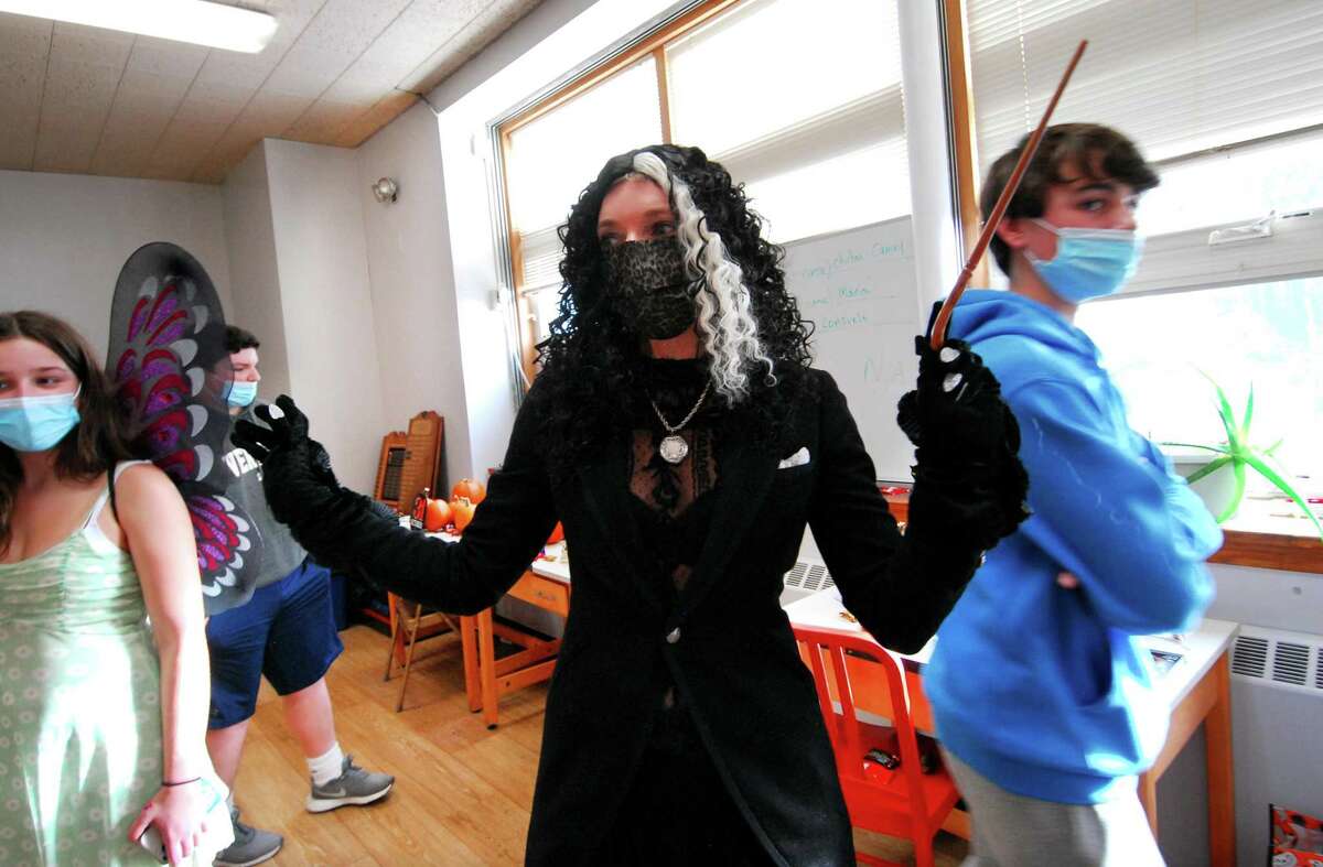 Kara Peters, teacher adviser with Greenwich High School's Students Give Back club, arrives dressed up as Harry Potter character Bellatrix Lestrange, to entertain children at Community Centers Inc. in Greenwich, Conn., on Thursday October 28, 2021. Several students from GHS's CCI Club and Students Give Back Club helped the kids decorate pumpkins, hid candy around the rooms for them, played games, did facepainting and other fun Halloween activities.