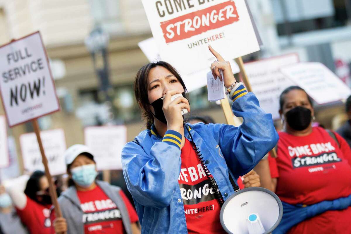 Nicole Huang speaks on a megaphone during a march through in downtown San Francisco on Thursday. Hospitality workers, union organizers and supportive demonstrators descended on the Westin St. Francis hotel in the city to demand better jobs.