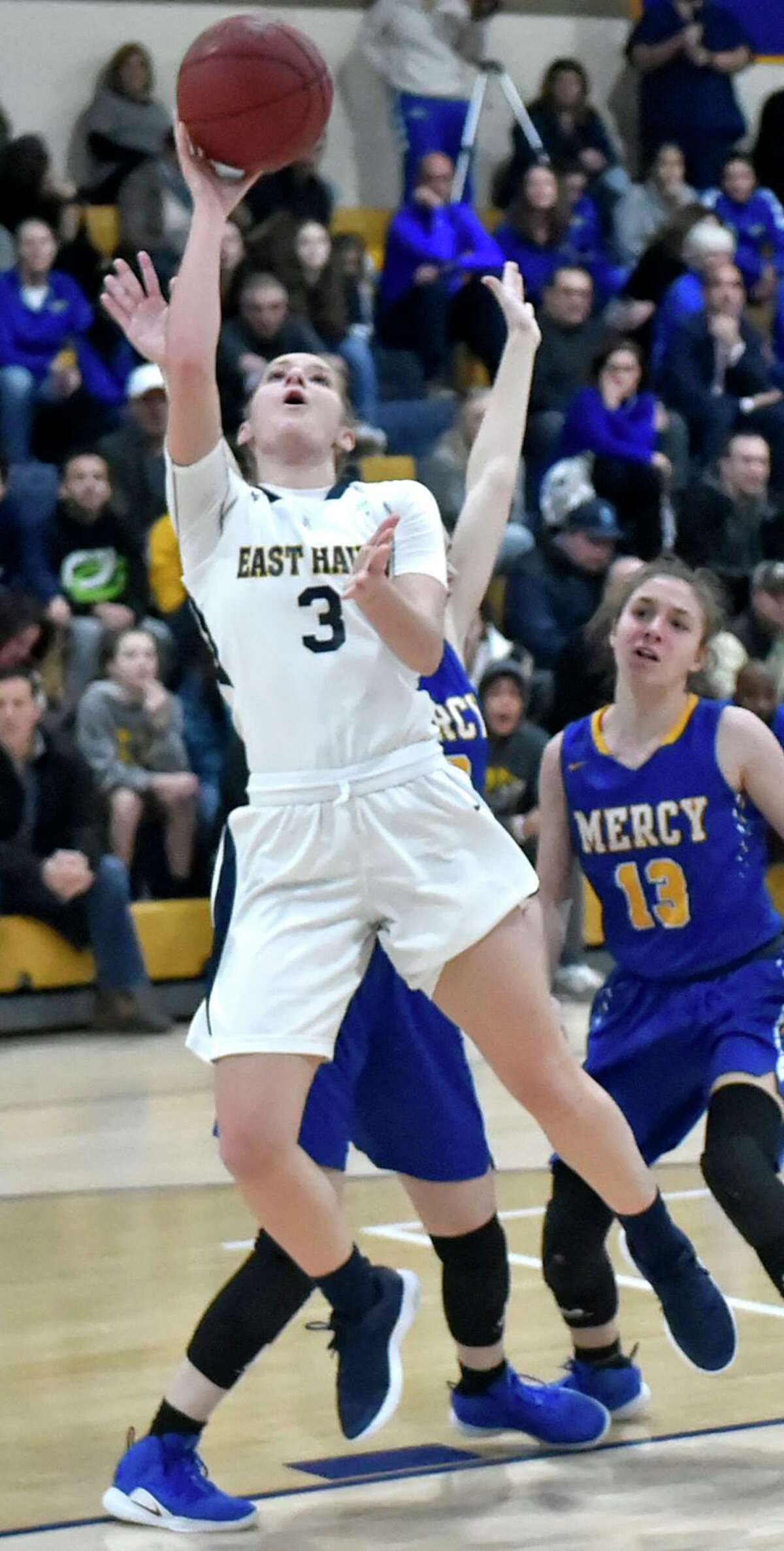 East Haven, Connecticut - Monday, February 11, 2019: Makenzie Helms of East Haven H.S. gets by Mercy H.S. of Middletown defenders Monday evening during second the quarter of girls basketball at East Haven H.S.