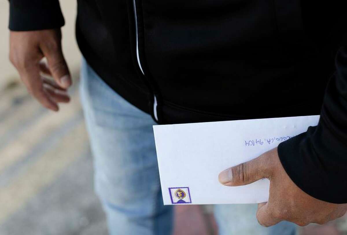 H.C. holds an envelope with his change of address forms on Monday, Oct. 25, 2021, in San Mateo, Calif. The form is weeks late because the instructions were in English, a language he doesn’t speak.