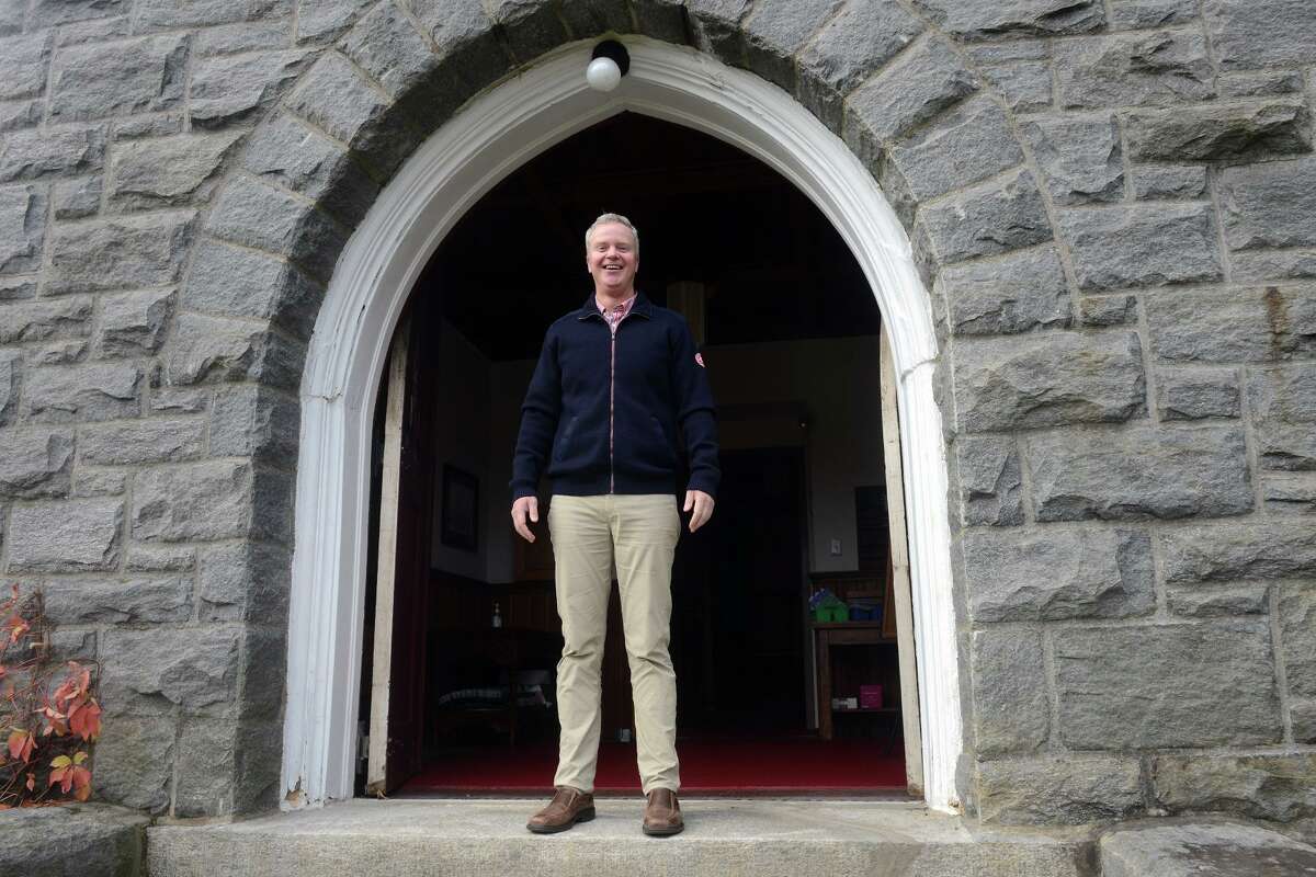 Rev. Timothy Hare poses on the front steps of Trumbull Congregational Church, in Trumbull, Conn. Oct. 28, 2021.