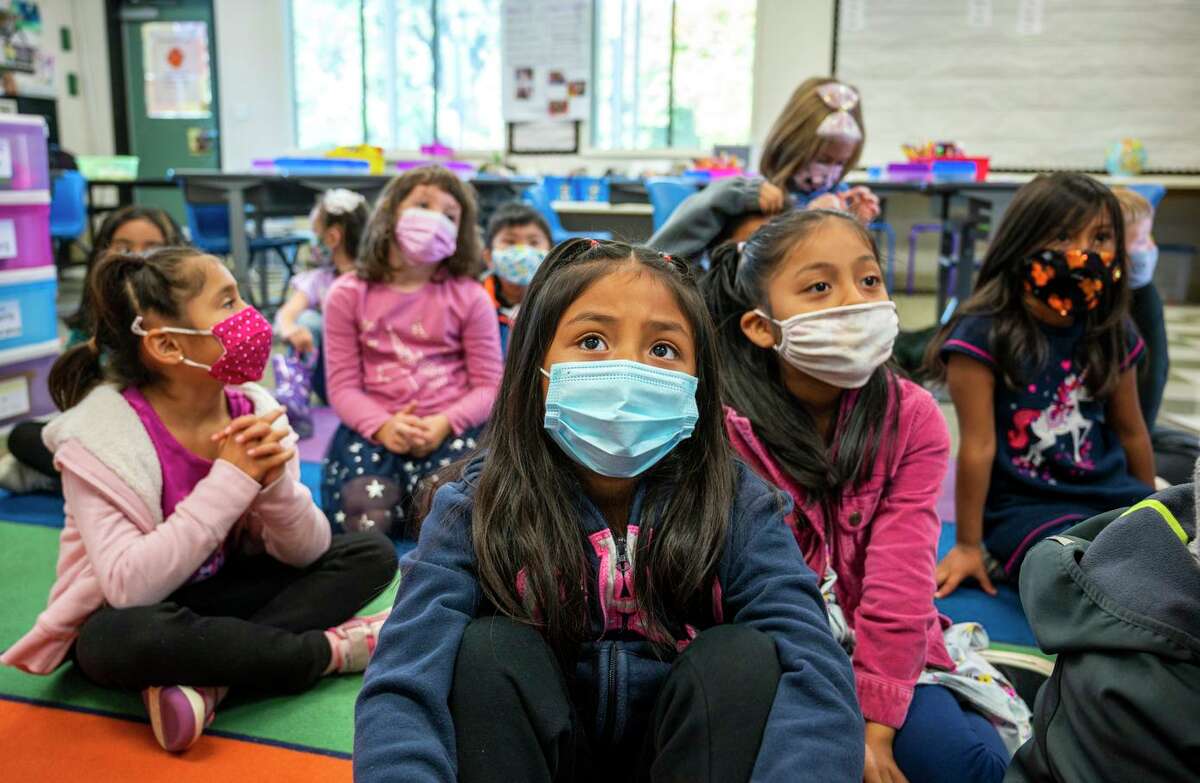 Madelin Quijivix Acaba (center) and Amy Lopez Vail (right) listen to a story in Emma Ellis’ first-grade glass at Coleman Elementary School in San Rafael.