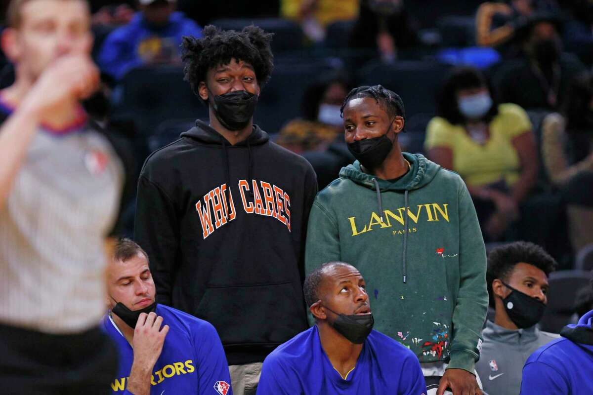 Golden State Warriors center James Wiseman and Warriors forward Jonathan Kuminga on the bench react to the skill of Warriors guard Stephen Curry, who is playing in the first half of an NBA game against the Portland Trail Blazers at Chase Center, Friday, Oct. 15, 2021, in San Francisco, Calif.