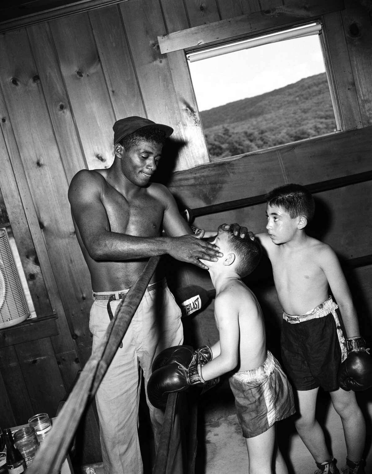 Fighter Floyd Patterson, who trained under Cus D'Amato, takes time out to coach a couple of young boys at Patterson's training camp on May 12, 1956 at Greenwood Lake, in Orange County. Patterson at age 21 became the youngest heavyweight champ at the time - Mike Tyson would achieve the milestone at age 20.