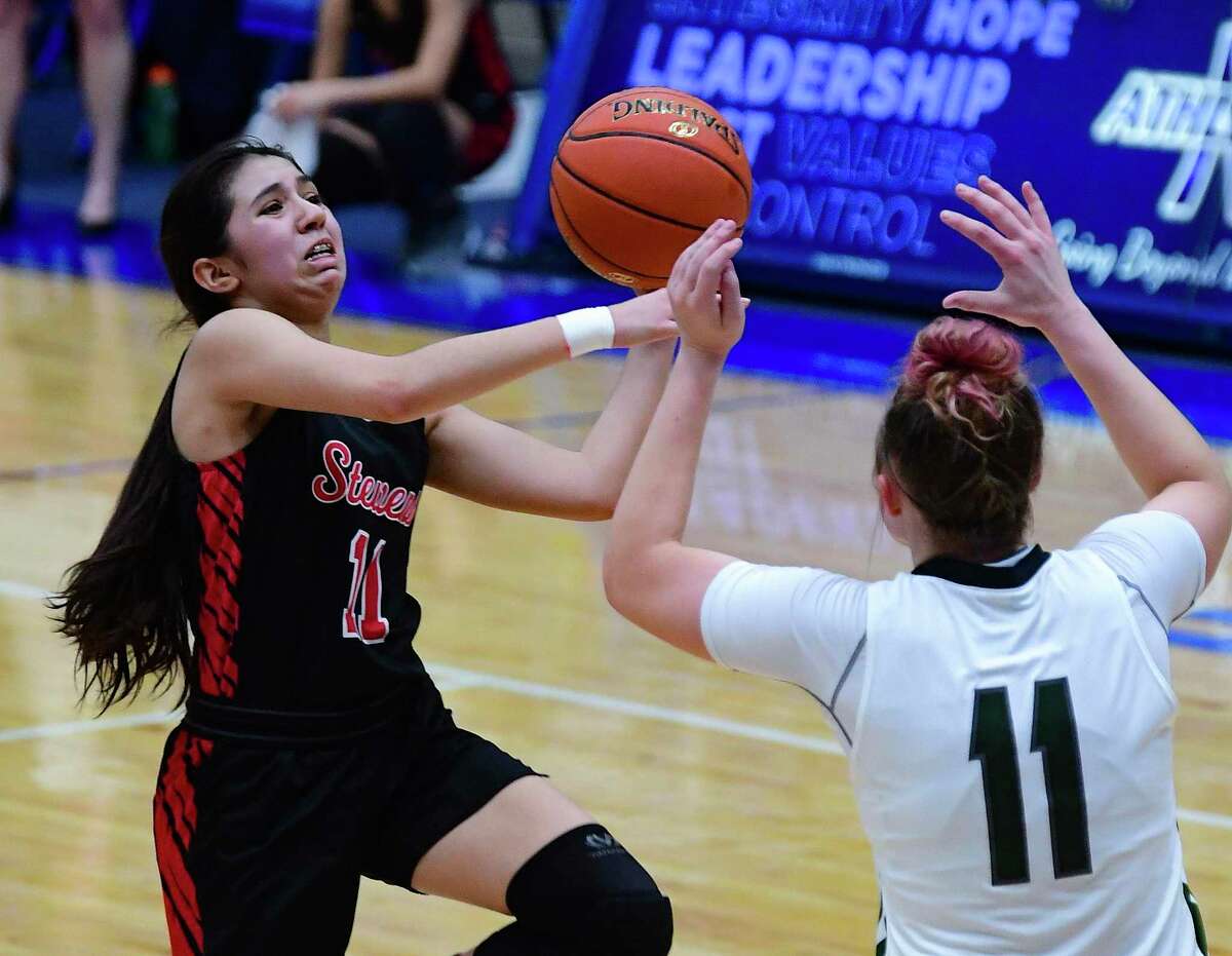 Annalia Cuellar of Stevens shoots and scores Samantha Wagner of Reagan defends during the Regional Semifinal at Northside Gym on Friday, Feb. 26, 2021.