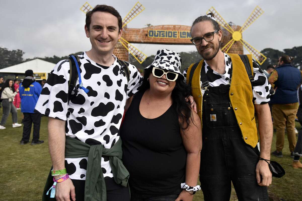 From left: Zack, Regina and Woody from Los Angeles head show off their cow print outfits while heading towards the Lands Ends stage, at Outside Lands, on Saturday, Oct. 29, 2021.