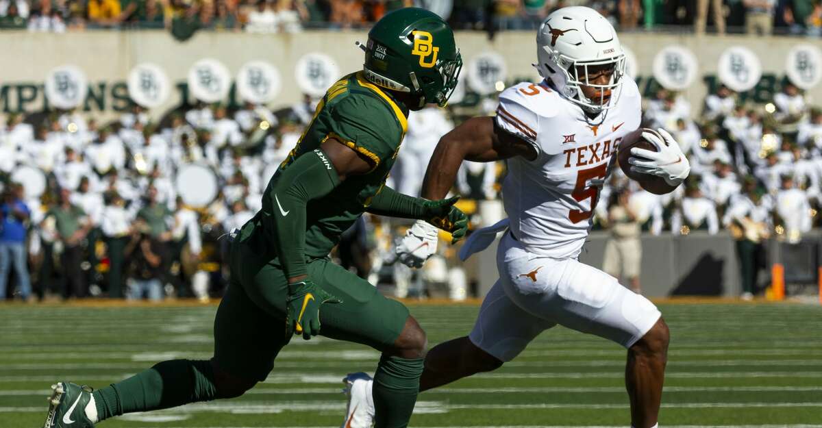 Texas running back Bijan Robinson (5) carries the ball in front of Baylor safety Christian Morgan (4) during the first half of an NCAA college football game, Saturday, Oct. 30, 2021, in Waco, Texas. (AP Photo/Sam Hodde)