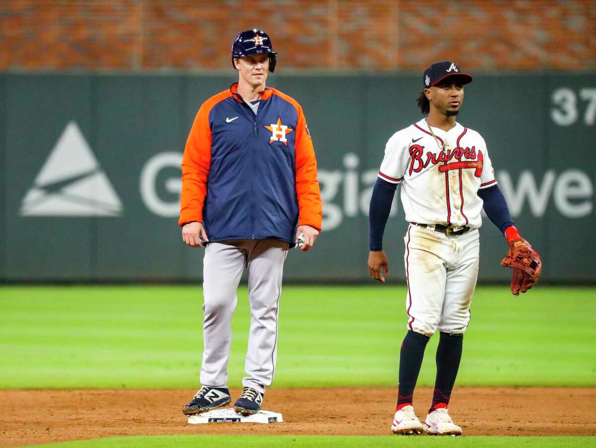 Houston Astros pitcher Zack Greinke (21) wears a jacket as he stands on second base next to Atlanta Braves second baseman Ozzie Albies (1), driven there by a single by Houston Astros catcher Martín Maldonado (15) during the second inning of Game 4 of the World Series on Saturday, Oct. 30, 2021 at Truist Park in Atlanta.