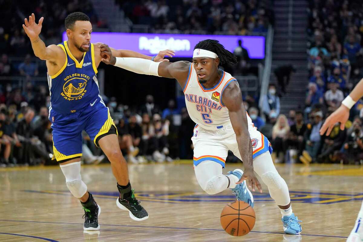 Oklahoma City Thunder forward Luguentz Dort (5) is defended by Golden State Warriors guard Stephen Curry (30) during the first half of an NBA basketball game in San Francisco, Saturday, Oct. 30, 2021. (AP Photo/Jeff Chiu)