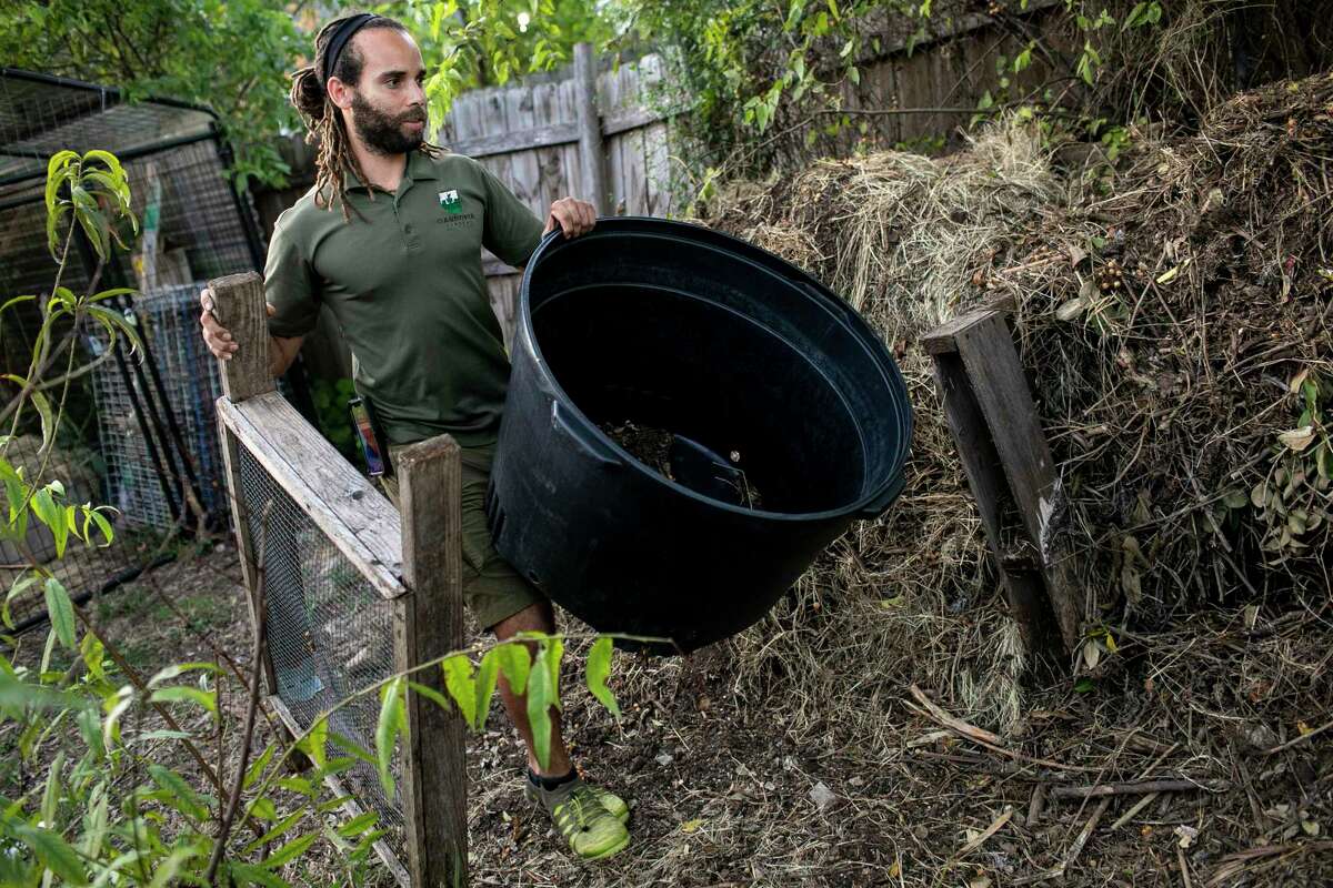 Stephen Lucke, CEO of Gardopia Gardens, carries the tools used to strain compost at Gardopia Gardens in San Antonio, Texas, on Oct. 21, 2021.
