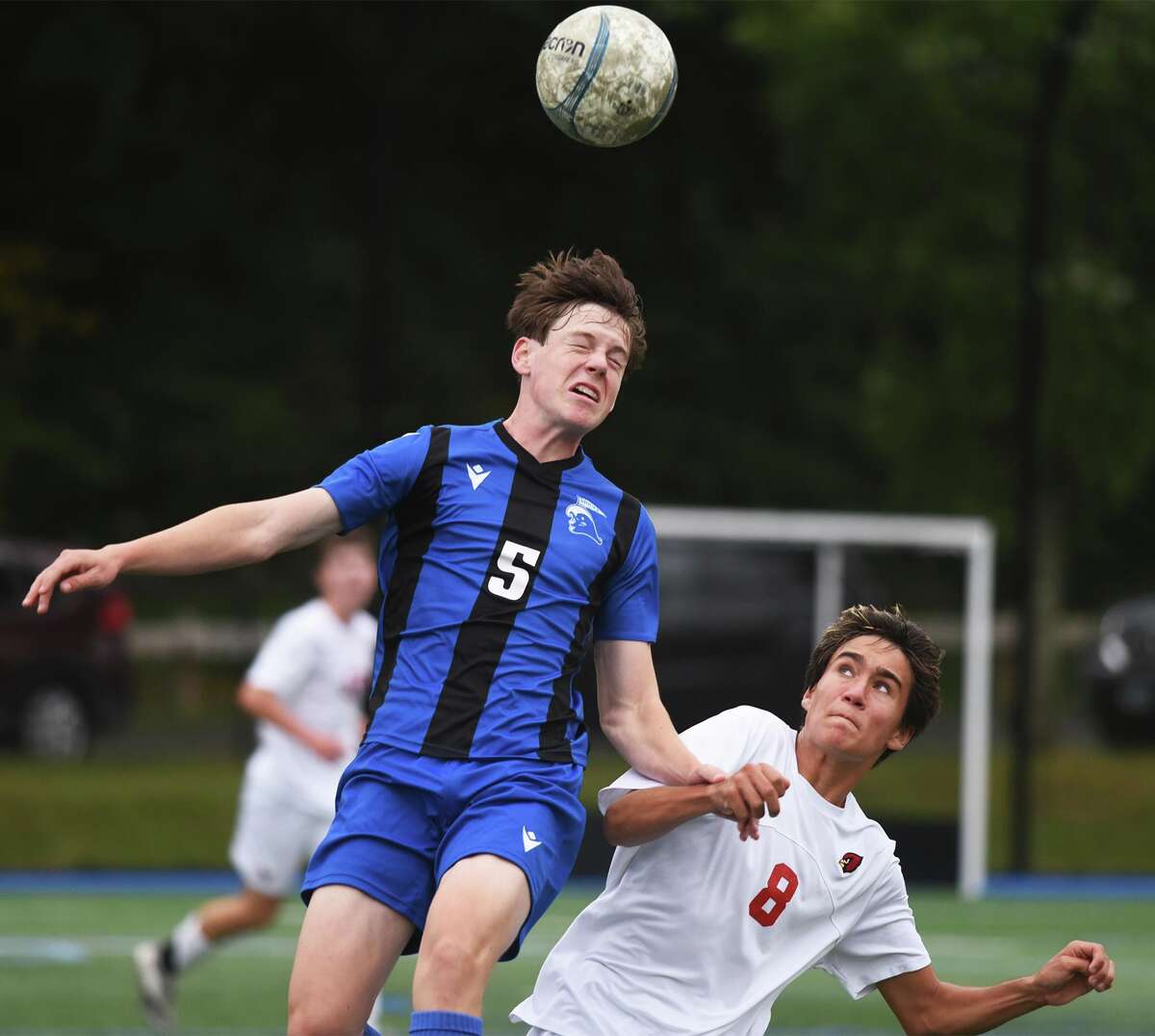 Darien's Trevor Pegg (5) goes up for a header over Greenwich's Maximo Acosta (8) during a boys soccer game at Darien High School on Tuesday, Oct, 5, 2021.