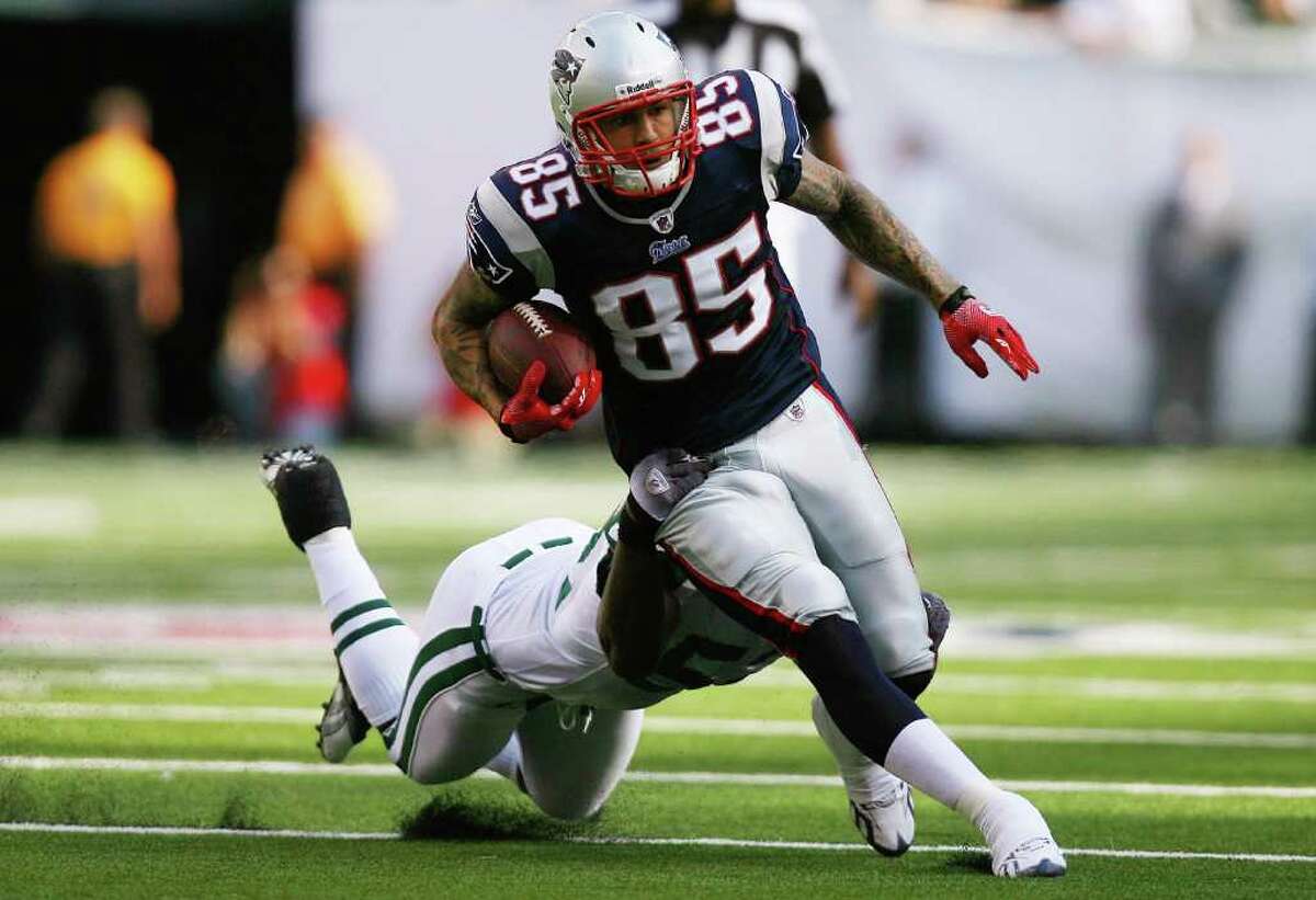EAST RUTHERFORD, NJ - SEPTEMBER 19: Aaron Hernandez #85 of the New England Patriots runs through a tackle from David Harris #52 of the New York Jets during the first quarter at the New Meadowlands Stadium on September 19, 2010 in East Rutherford, New Jersey. (Photo by Andrew Burton/Getty Images) *** Local Caption *** Aaron Hernandez;David Harris