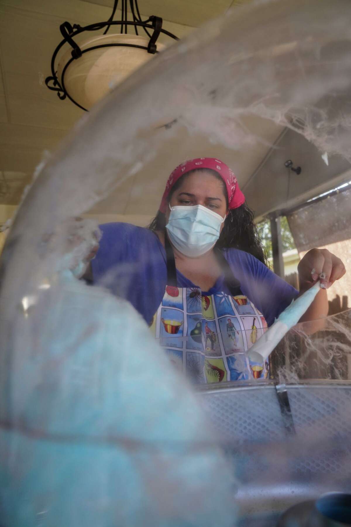 Angela Menchaca makes cotton candy during the annual Menchaca family Halloween tradition on the West Side. This Halloween, everyone involved has been vaccinated, will wear masks, and take a COVID test prior to the event.