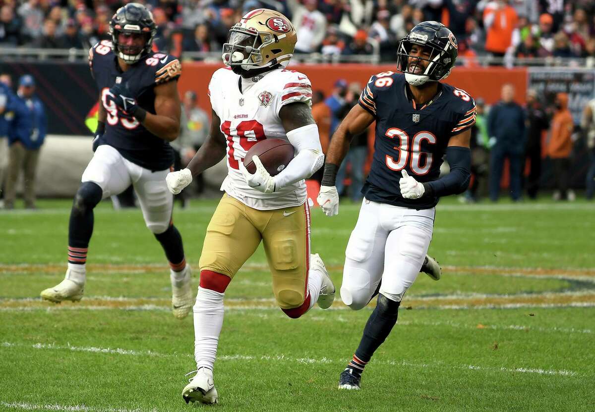 Deebo Samuel of the 49ers is chased by DeAndre Houston-Carson (right) of the Chicago Bears.