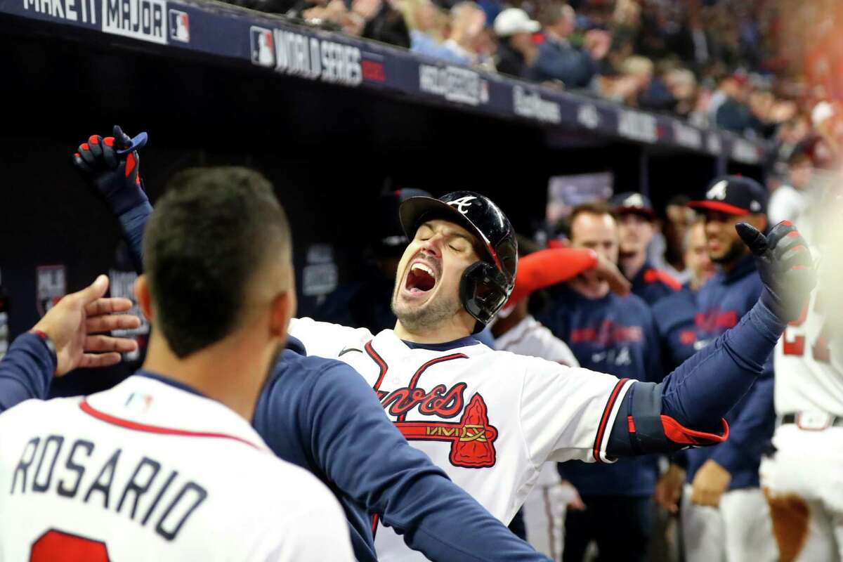 Atlanta Braves center fielder Adam Duvall celebrates his grand slam home run to put the Braves up 4-0 with teammates in the dugout during the first inning against the Houston Astros in Game 5 of the World Series at Truist Park, Sunday, Oct. 31, 2021, in Atlanta. (Curtis Compton/The Atlanta Journal-Constitution/TNS)