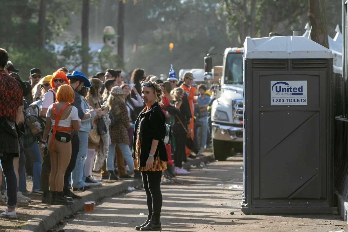 A woman stands outside portable toilets at Outside Lands in Golden Gate Park in San Francisco on Oct. 31, 2021.