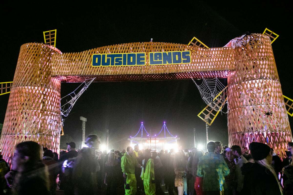 People walk under the windmills at Outside Lands in Golden Gate Park in San Francisco on Oct. 31, 2021.