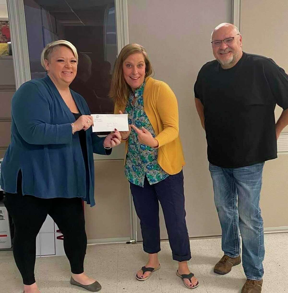 Mayor Chris Emerick (left) and Evart Chamber of Commerce director Eric Schmidt (right) present a donation check to Jessica Kolenda (center), Evart High School principal, for the Promise Plus program. (Submitted photo)