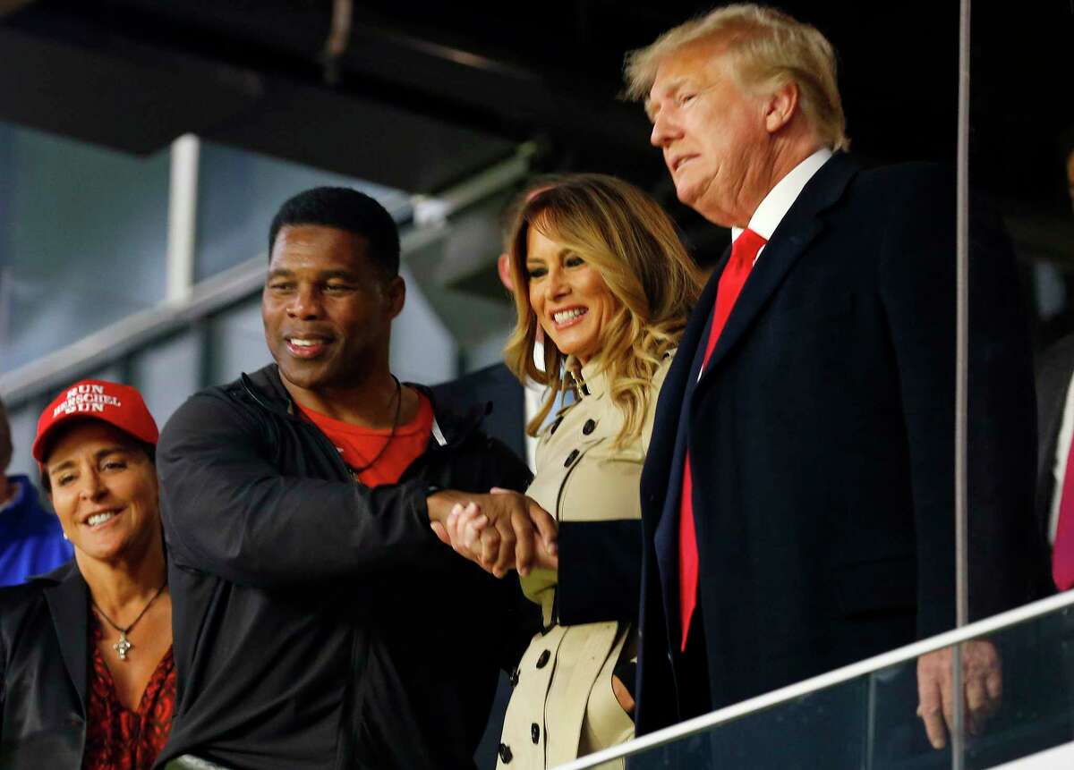 Former football player and political candidate Herschel Walker interacts with former President Donald Trump prior to Game Four of the World Series between the Houston Astros and the Atlanta Braves at Truist Park on Oct. 30, 2021, in Atlanta.