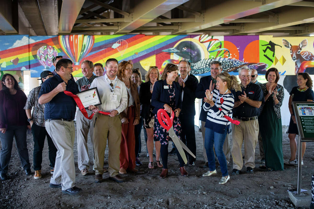 Community leaders gather for a ribbon cutting ceremony for the new mural underneath the M-20 bridge Tuesday, Oct. 5, 2021 in downtown Midland. (Katy Kildee/kkildee@mdn.net)