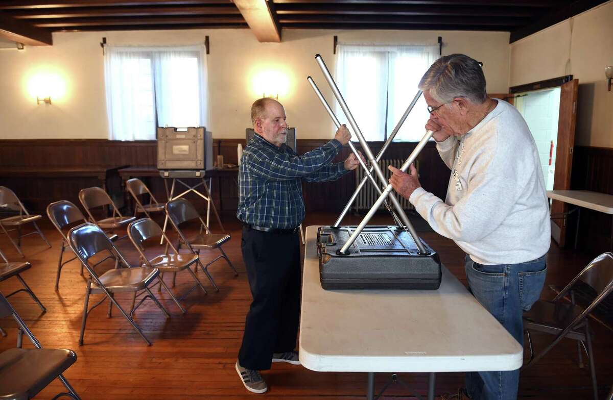 Moderator Richard Hannan, Jr., (left) and church member Ralph Lawson assemble voting booths for election day at a polling place in the Church of the Holy Spirit in West Haven on Nov. 1, 2021.